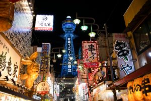 Colorful neon-lit street in bustling Osaka, showcasing vibrant urban nightlife.
