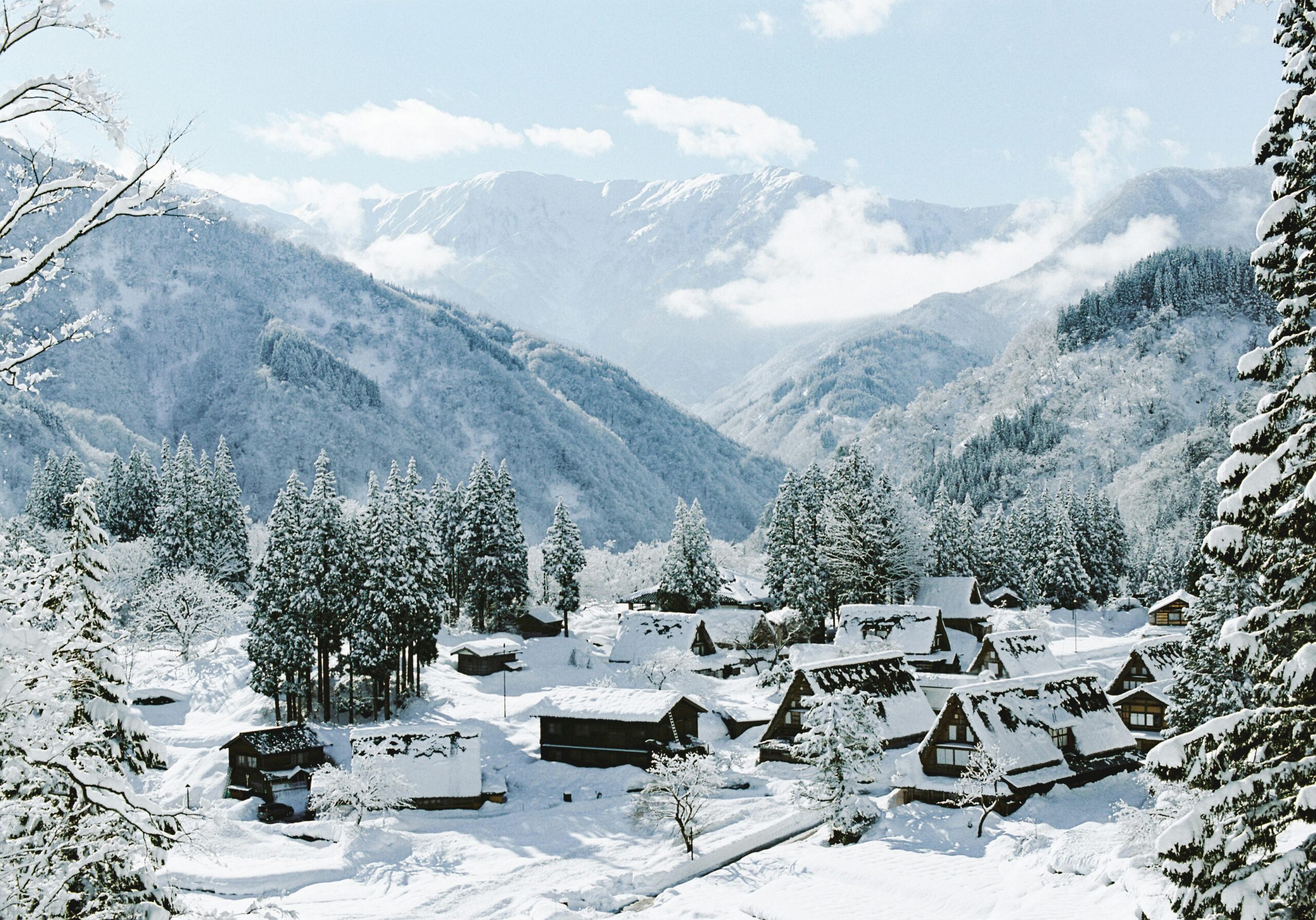 Idyllic winter scene of a snowy village nestled in mountain scenery.