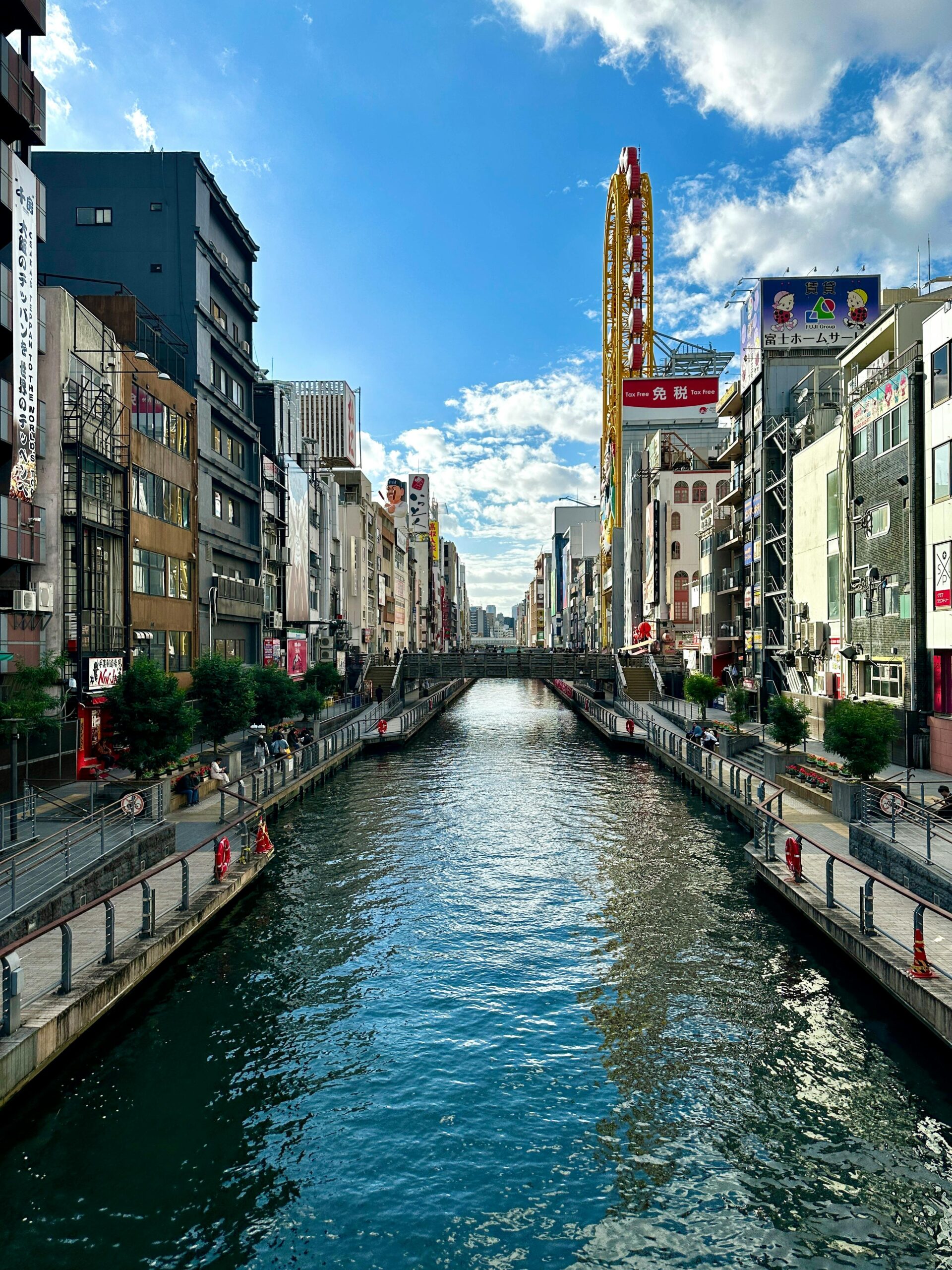 Explore the lively Dotonbori Canal in Osaka, Japan on a bright day, showcasing its urban charm.